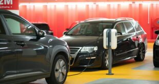 Hybrid- vs. Elektroauto. Autoaufladung in einer Garage.