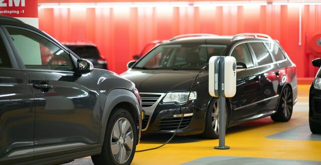 Hybrid- vs. Elektroauto. Autoaufladung in einer Garage.