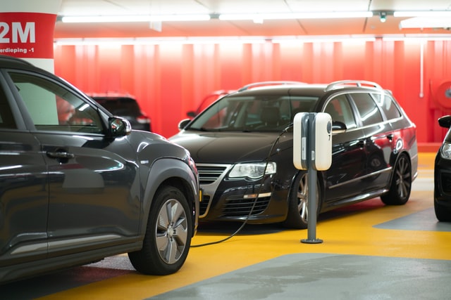 Hybrid- vs. Elektroauto. Autoaufladung in einer Garage.