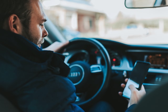 Reaktionszeit. Ein Fahrer das Handy am Steuer benutzt