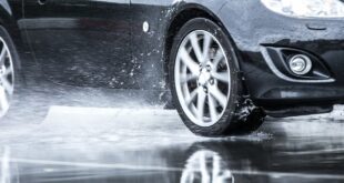 Auto fährt über eine Pfütze.
