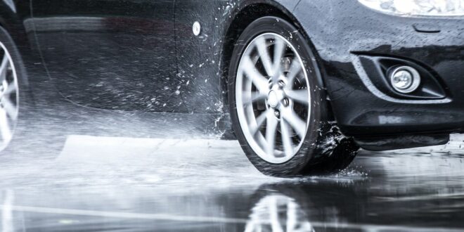 Auto fährt über eine Pfütze.