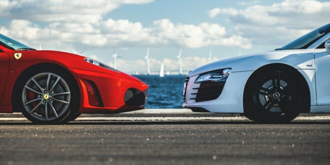Ein weißes Auto und ein rotes parken parallel zueinander.