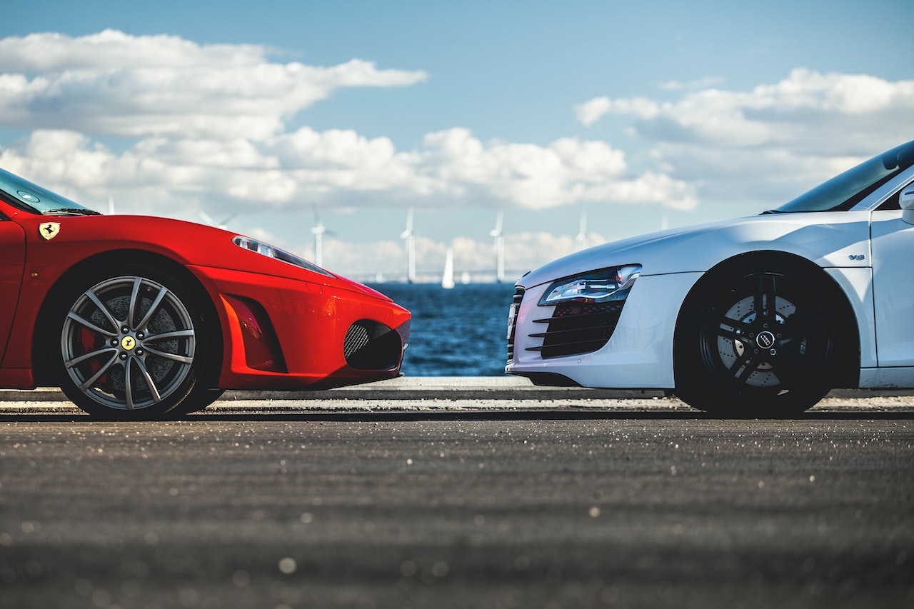 Ein weißes Auto und ein rotes parken parallel zueinander.