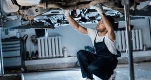 Ein Mechaniker überprüft den Zustand eines Fahrzeugs in der Werkstatt.