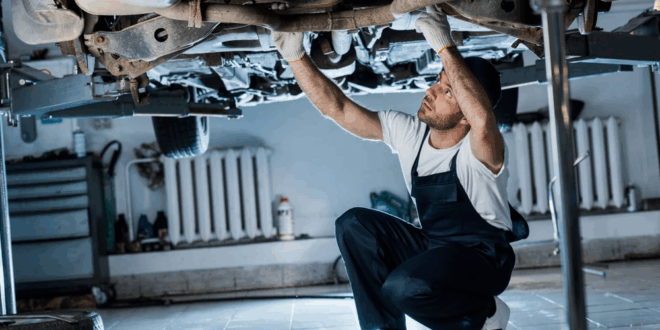 Ein Mechaniker überprüft den Zustand eines Fahrzeugs in der Werkstatt.