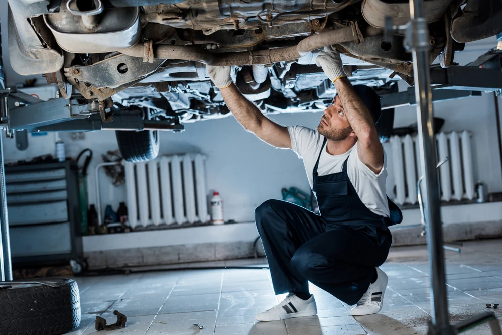 Ein Mechaniker überprüft den Zustand eines Fahrzeugs in der Werkstatt.
